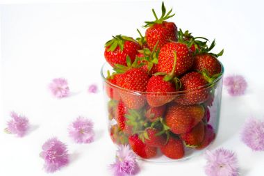 Cam bardak ve pembe çiçekler çilek. Beyaz backg
