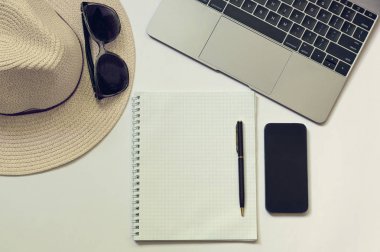 Bir blogger, yazar veya serbest meslek sahibi bir dizüstü bilgisayar, açık defter, telefon, kalem, şapka ile çalışma alanı. Beyaz arka plan kopya alanı ile. Tonda fotoğraf. Yukarıdan görüntülemek
