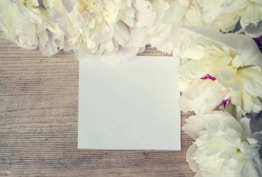 Kartpostal tebrik kartı ile ahşap bir tahtada beyaz çiçek çerçeveli için boş bırakın. Kadar alay et. Vintage tonlama. Kopya alanı. 