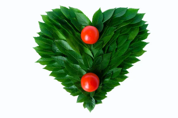 Tomates no fundo do coração de folhas verdes. O conceito de amor à natureza e nutrição racional — Fotografia de Stock