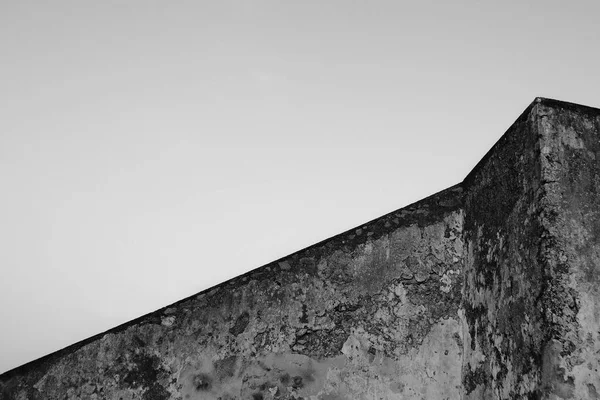 Imagen en blanco y negro. Geometría del edificio. Antiguo muro de hormigón en el fondo del cielo. Arquitectura abstracta . —  Fotos de Stock