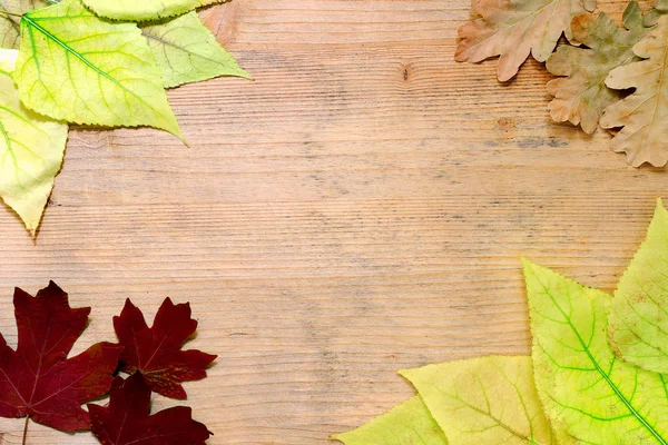 Na podzim složení - žluté a červené listy na dřevěné pozadí. Kopírovat prostoru. Podzimní pozadí — Stock fotografie