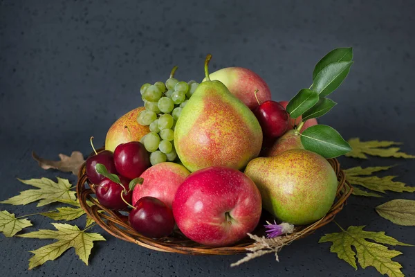 Komposition aus reifen Früchten und gelben Herbstblättern auf schwarzem Hintergrund. Erntekonzept — Stockfoto