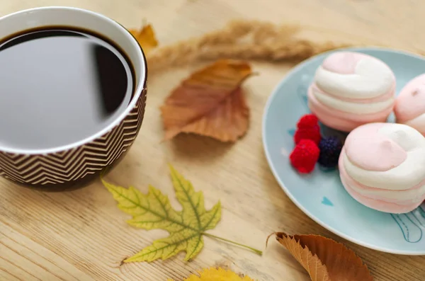 Autumn relaxation - a cup of coffee, marshmallow, autumn yellow  leaves.