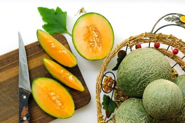 Beyaz arka plan ve ahşap tahta üzerinde taze olgunlaşmış kavun ile kompozisyon. Seçici odak.