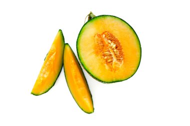 Ripe yellow melon with seeds cut in half with slices nearby. Isolate on white background. clipart