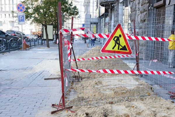 İş büyük şehirde yaya bölgesinin ortasında onarın. Kum kaldırım dökülür ve bir koruyucu bant ile çitlerle çevrili. — Stok fotoğraf