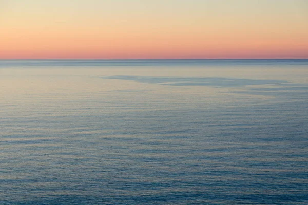 Мирный закат у моря. Спокойная вода и яркое небо . — стоковое фото