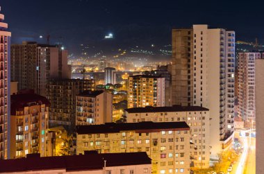 Yüksek binaları olan gece caddesi.