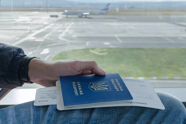 Adam elini uçak biletleri ile Ukrayna yabancı pasaport arka plan düzlem içinde tutuyor. Gezi Yurtdışı, vize ücretsiz rejimi, kavramı seyahat tatil ve özgürlük üzerinde seyahat etmek içinde.