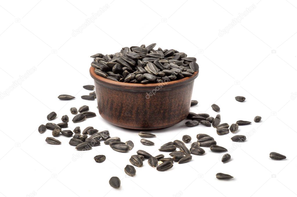 sunflower seeds toasted in clay pot on white background isolated