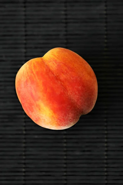 Ein reifer Pfirsich auf schwarzem Hintergrund. Sommerfrucht — Stockfoto