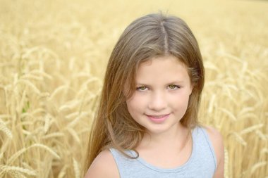 Yakın çekim 8 yaşındaki kız uzun saçlı yeşil gözlü altın Rye yaz günü alan. Saflık, büyüme, mutluluk kavramı