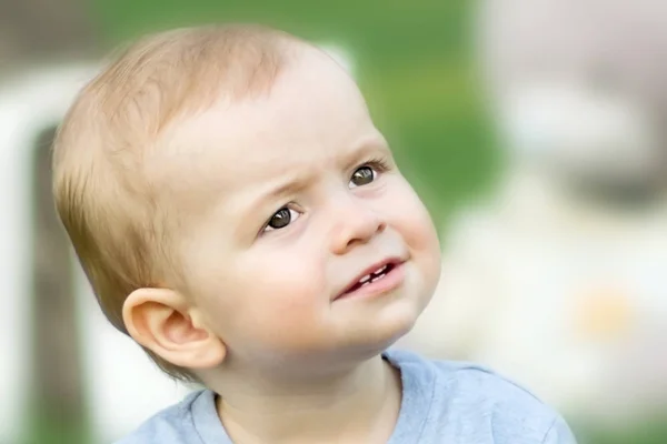 Close-up portrait of surprised little baby boy at summer day. Blurred background — Stock Photo, Image