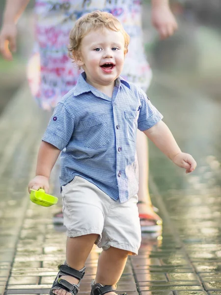 Speelse gelukkig grappig jongetje weglopen van zijn moeder en zomerdag lachen. Onscherpe achtergrond — Stockfoto