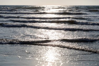 Deniz köpüğü ve spreyli Akdeniz dalgaları. Günbatımı arka planında güzel bir deniz. Gün batımı. Deniz Burnu. Su deseni