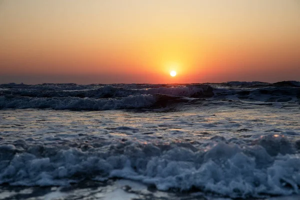 Waves of the Mediterranean Sea with sea foam and spray. Beautiful sea on sunset background. Sundown. Seascape.