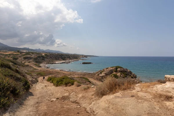 Mar Mediterrâneo no norte de Chipre. As ruínas de um antigo edifício na ilha. Praia do verão com água azul transparente. A paisagem marinha. Skyline com nuvens . — Fotografia de Stock