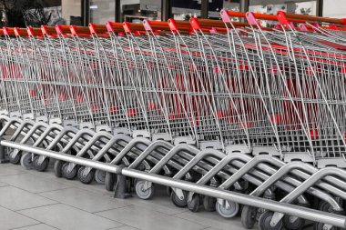 Büyük bir süpermarketin önünde uzun bir sıra alışveriş arabası ya da araba..