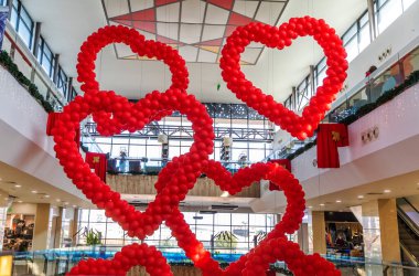 Kıbrıs - Şubat 2020: Sevgililer günü, tavandan sarkan alışveriş merkezinde kalp şeklinde kırmızı balonlar. Aşk Günü Kutlaması