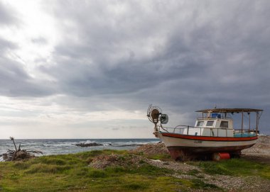 Eski ve kırık metal bir tekne Kıbrıs adasında deniz kıyısında karaya vurmuş..
