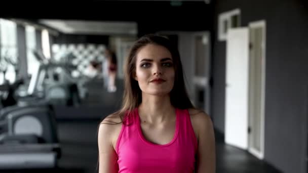 Portrait of walking Young pretty smiling female looking into camera in gym. Heathy lifestyle, sport conception. Slow motion Full HD video 1920X1080 — Stock Video