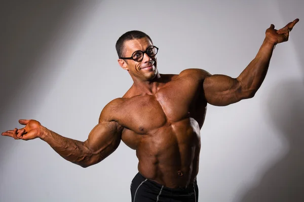 Hombre musculoso feliz con un torso desnudo y gafas divertidas — Foto de Stock