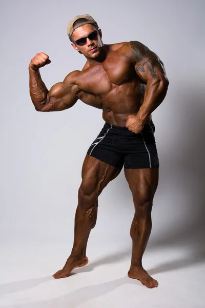 Athletic muscular man posing against — Stock Photo, Image