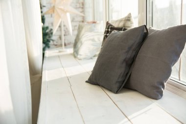 Kahverengi bir ahşap pencere pervazına minderler