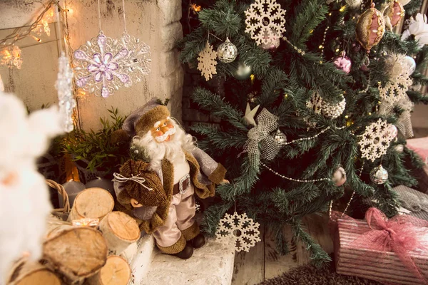 Игрушечный Санта с сумкой рядом с елкой — стоковое фото