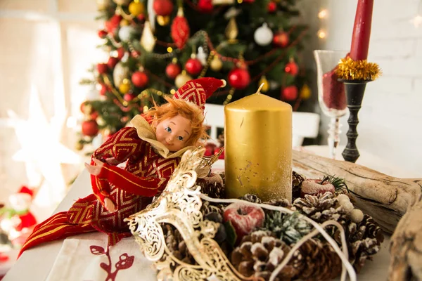 Em cones de mesa festivos, velas e boneca . — Fotografia de Stock