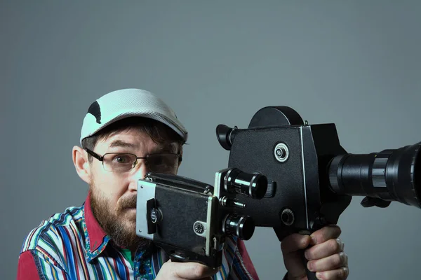 Skäggig man två gamla retro filmkamera — Stockfoto