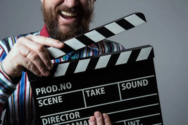 一个男人微笑 clapperboard 电影院的特写镜头 — 图库照片