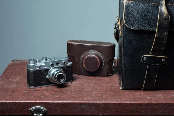 Camera and carrying case on old suitcase — Stock Photo, Image