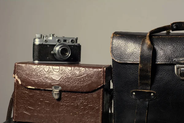 Close-up of a stack vintage shabby suitcases and camera — Stock Photo, Image