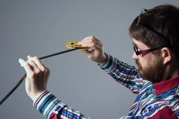 Bearded man looks at 8mm film — Stock Photo, Image