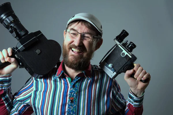 Skrattande bearded man två gamla retro filmkamera — Stockfoto