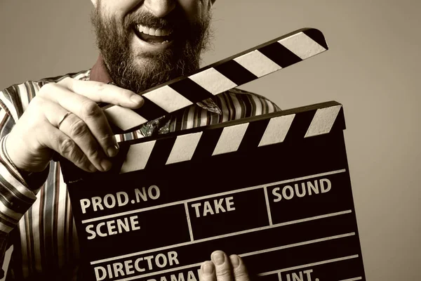 一个男人微笑 clapperboard 电影院的特写镜头 — 图库照片