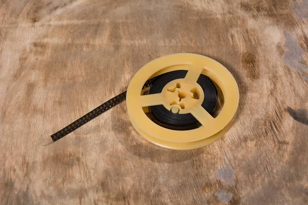 Spule mit 8 mm Folie liegt auf einer Holzoberfläche — Stockfoto