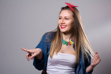 Gülümseyen kadın tarafında görünüyor ve bir parmağını gösterir