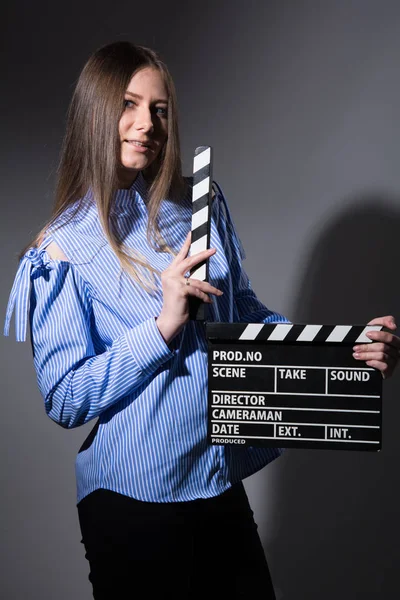 Jonge vrouw in een gestreepte shirt met film klepel. — Stockfoto