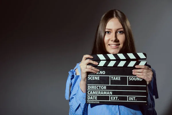 Close-up of a girl with a movie clapper