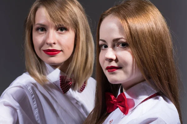 Dos hermosas chicas con mariposas alrededor de sus cuellos en camisas ligeras . — Foto de Stock