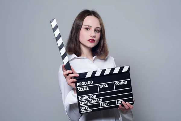 Девушка в белой блузке с кинокрекером — стоковое фото