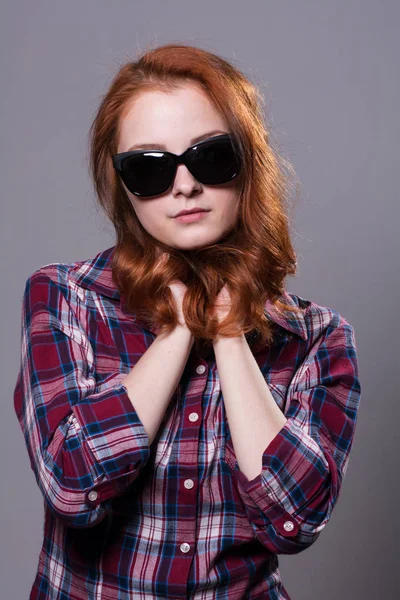 Portrait d'une belle femme aux cheveux roux portant des lunettes de soleil . — Photo