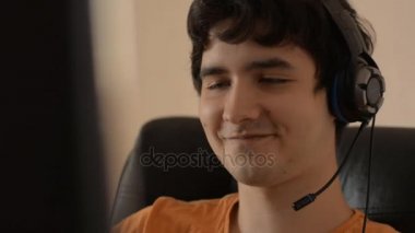 Bir bilgisayarda çalışma kulaklık ile genç bir adamın yakın çekim
