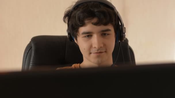 Close-up of a young man with headphones working on a computer — Stock Video