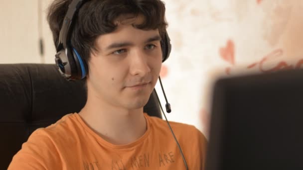 Junger Mann mit Kopfhörer und Computer — Stockvideo