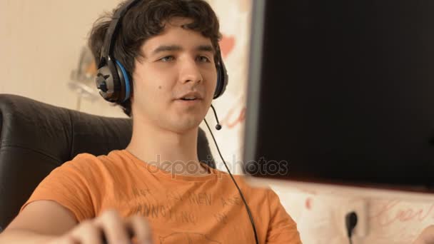 Fiatal férfi fejhallgató dolgozik a számítógépen. — Stock videók