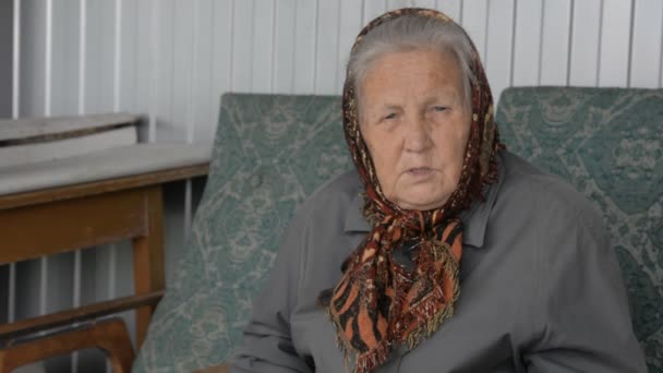 Портрет пожилой женщины в коричневом платке — стоковое видео